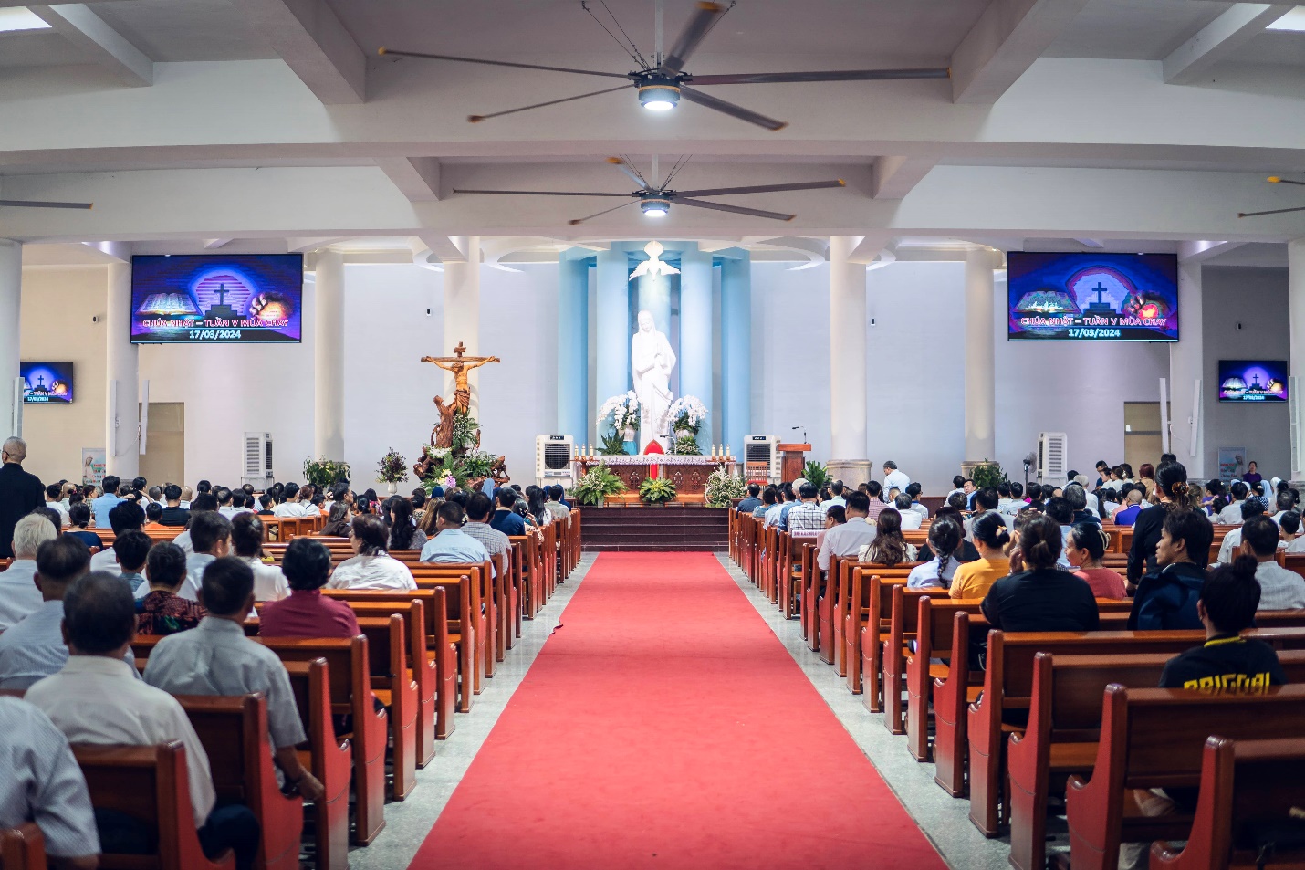 A group of people sitting in a church Description automatically generated